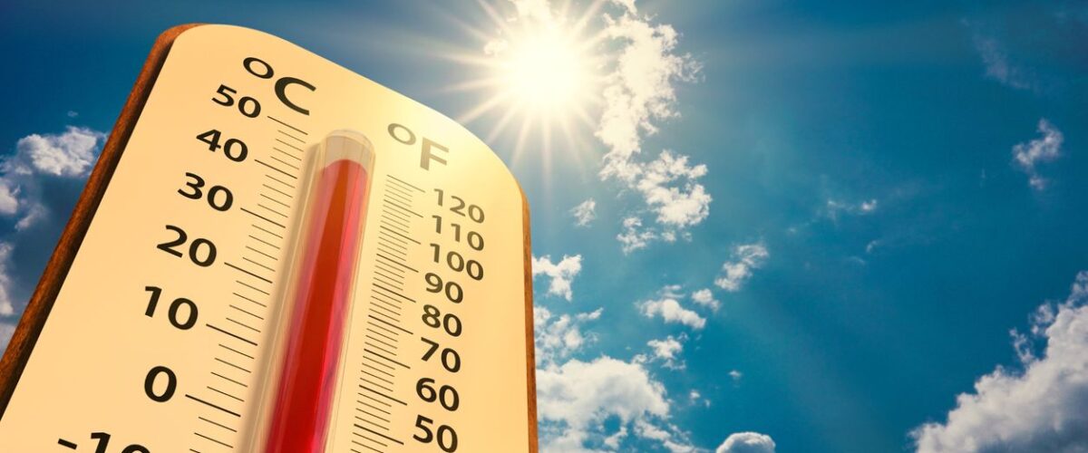 A thermometer set against a backdrop of a blue sky with the sun.