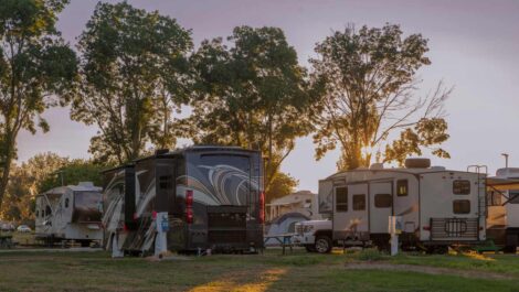 A sunset at an RV park with many motor homes.